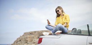 Sådan finder du ud af om din bil trænger til vedligeholdelse Person sidder oven på grå bil